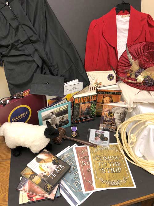 Books, booklets, DVDs, large red had with flowers, and other items from the Women of Oklahoma trunk